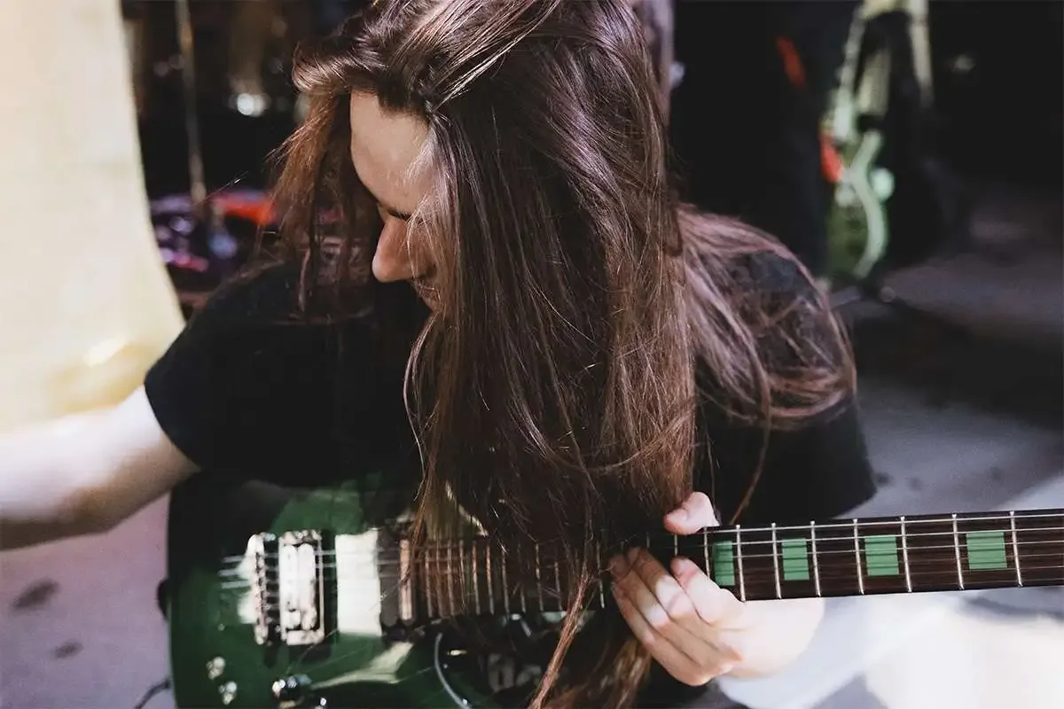 Guitarist of Dead Again tuning his guitar, setting the stage for a powerful gothic metal tribute.